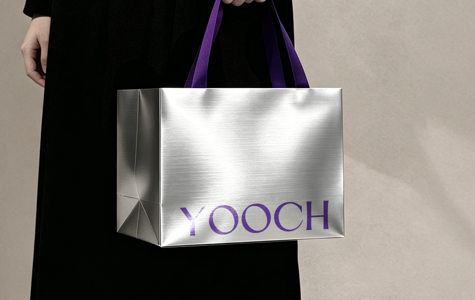 宏洛图作品案例-YOOCH 高端医美私护品牌手提袋,金属拉丝银特种纸礼品袋,紫色织带提手 + 紫色品牌字母印刷,线下礼盒配套购物袋包装设计实拍